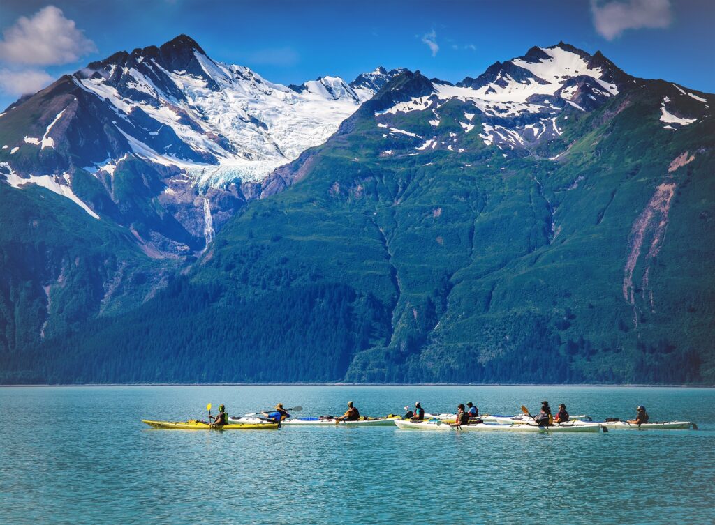 Kayakers paddling with glacier views